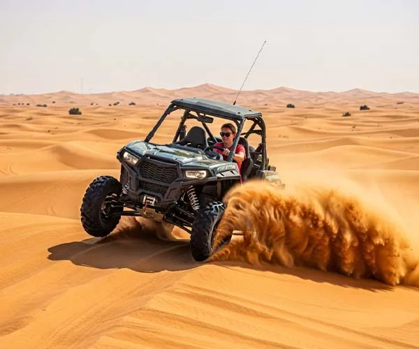A traveler driving a powerful off-road dune buggy through the red sand dunes of Dubai, creating a large sand spray.
